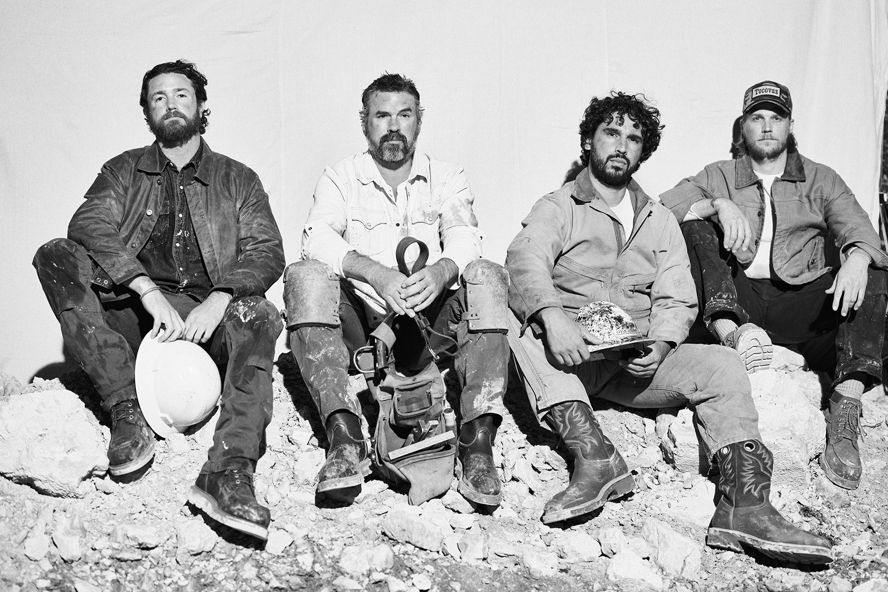 A group of construction works sit on some rocks for a portrait in their Tecovas workwear boots.